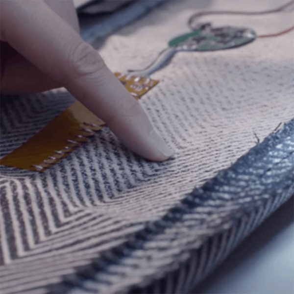 Nahaufnahme eines Smart Textiles mit integrierter Elektronik und leitfähigen Verbindungen auf textilem Material.